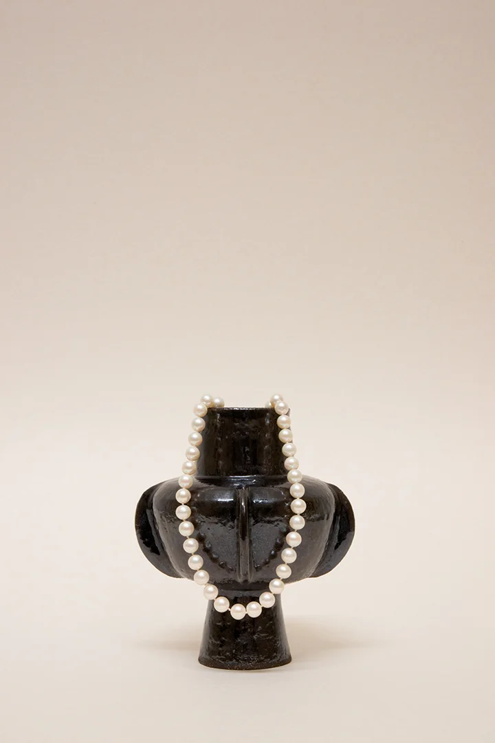 Artisanal handmade wheel-thrown ceramic vase tableware set. Dark Glaze ceramics. Hand built vessel with white pearl necklace