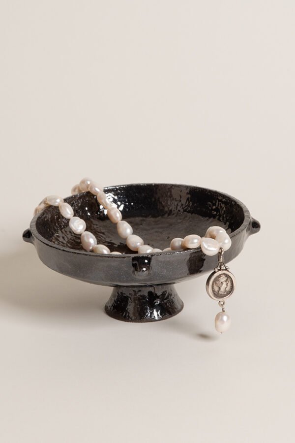 Artisan wheel-thrown ceramic plate bowl black glazing and pearl necklace inside